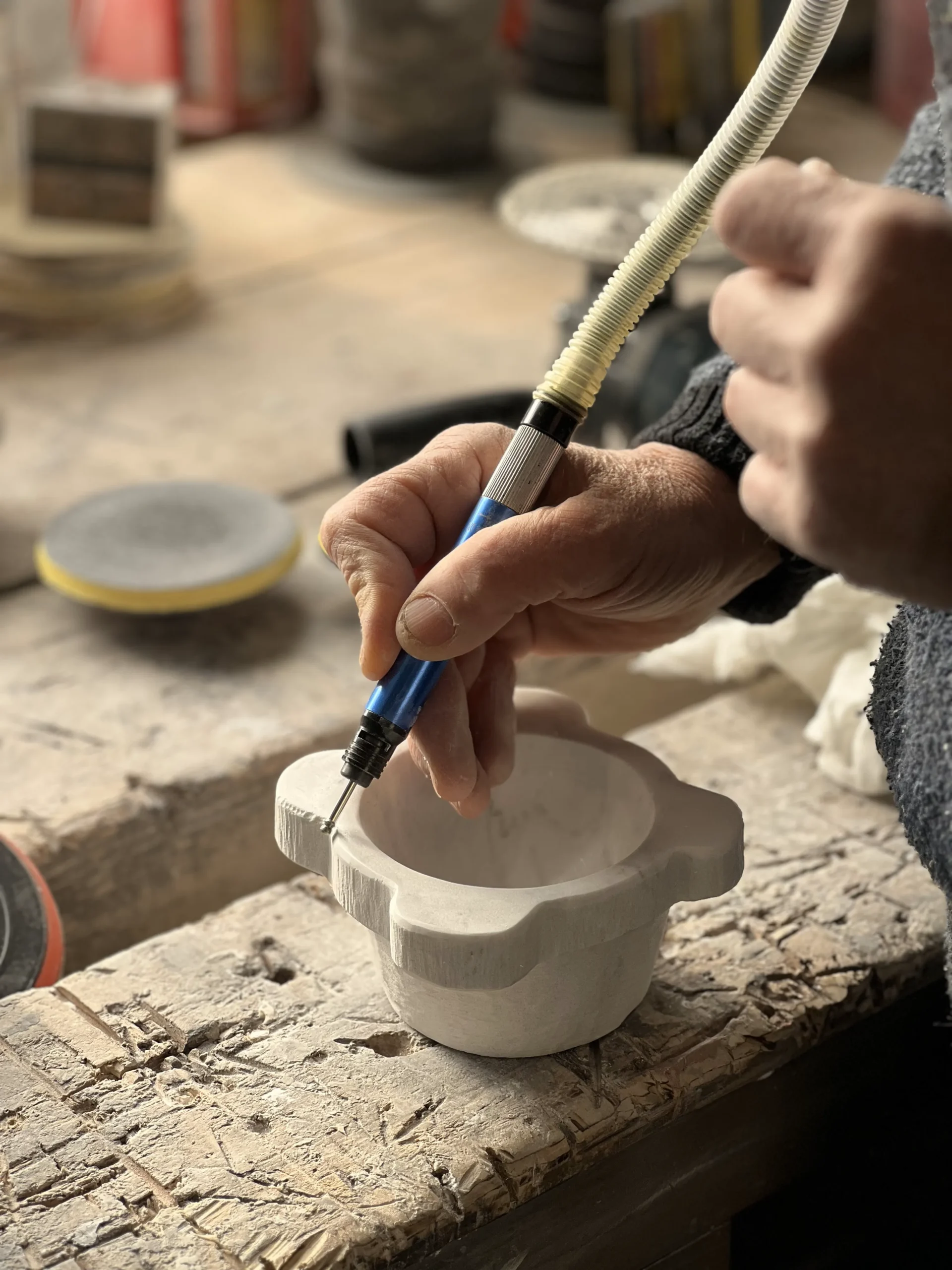 Mani che lavorano il marmo nella bottega